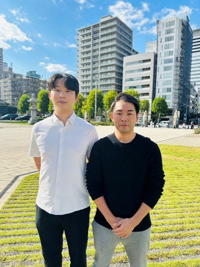 オフィス近くの屋外で並ぶ社員2名